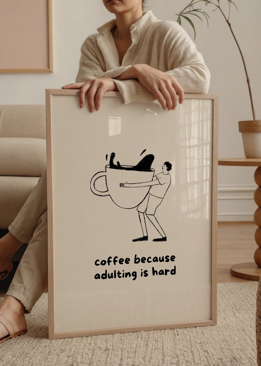 Kahve fincanını saran bir figürün bulunduğu çizim ve altında "coffee because adulting is hard" yazılı espirili tipografik poster.