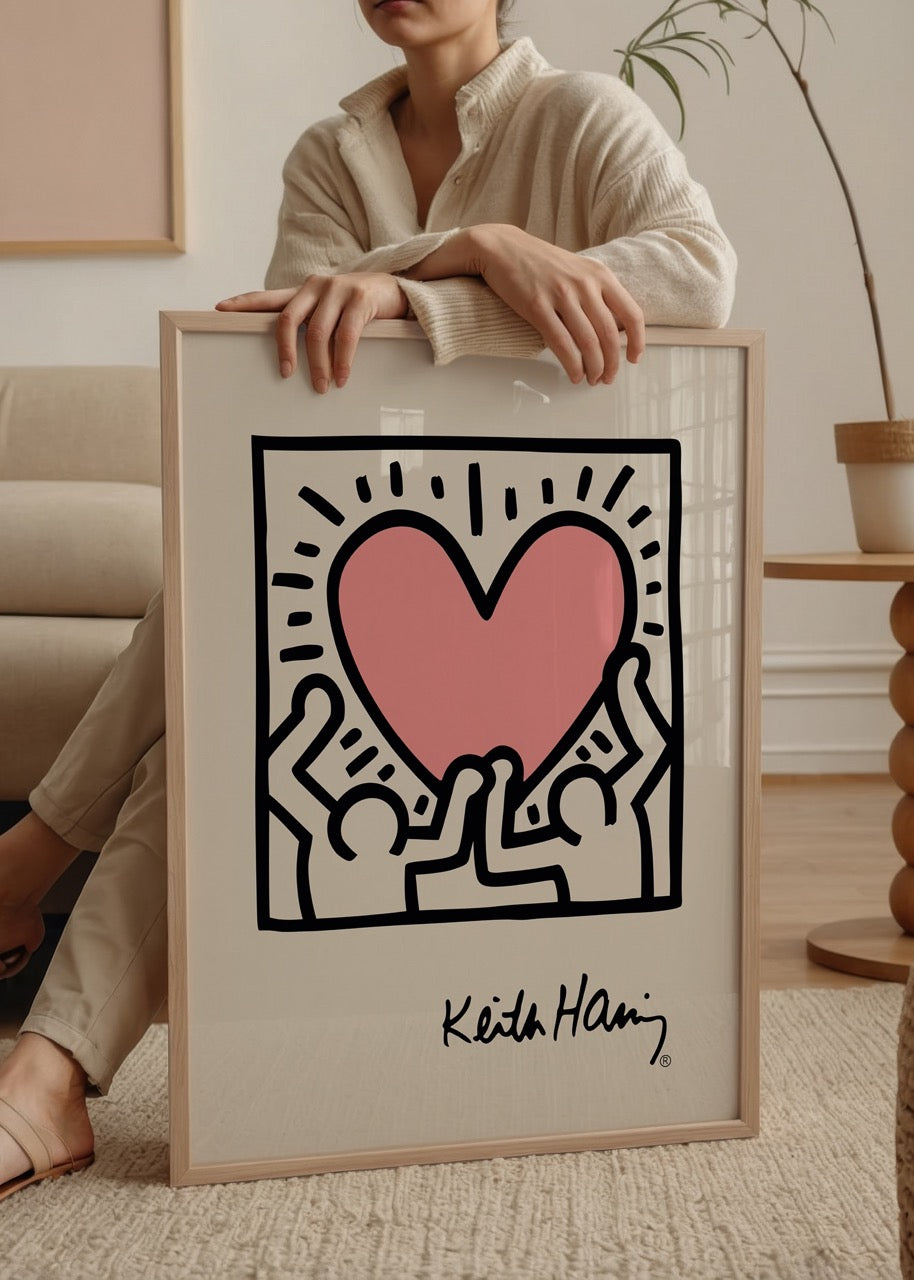 Keith Haring’in üç figürün pembe bir kalbi birlikte kaldırdığı pop art duvar posteri