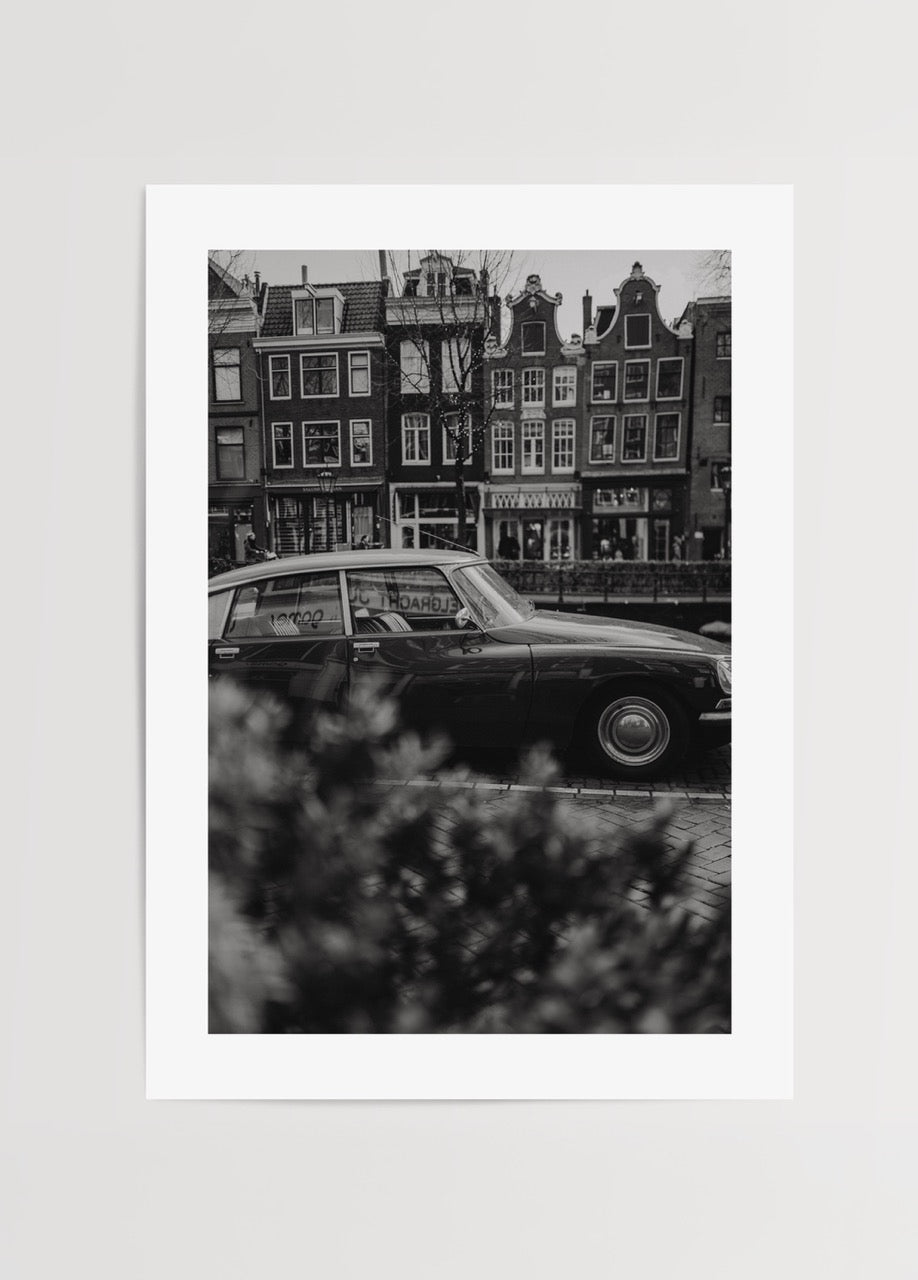 Amsterdam kanalında klasik araba ve tarihi evler siyah beyaz fotoğraf