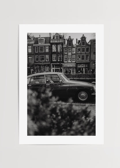 Amsterdam kanalında klasik araba ve tarihi evler siyah beyaz fotoğraf