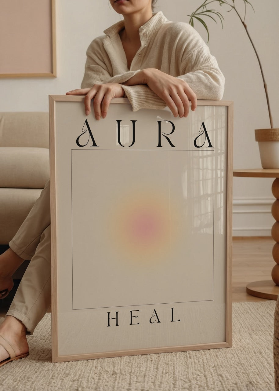 Bej zemin üzerinde merkezden yayılan yumuşak sarı, turuncu ve pembe ışık halkalarıyla tasarlanmış; “Aura” ve “Heal” yazılı modern, spiritüel temalı sanat posteri.