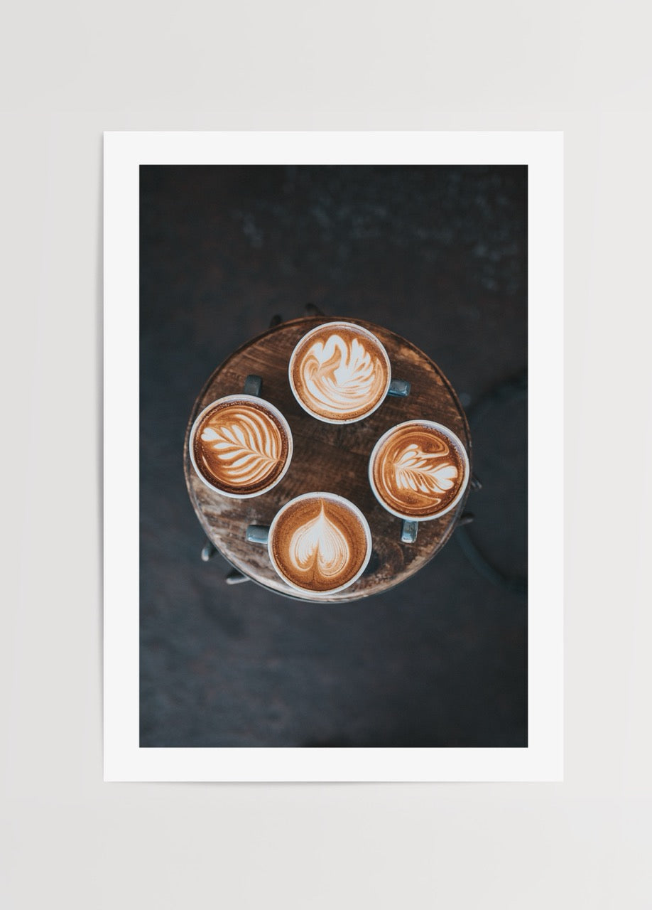Rustik masa üzerinde latte art desenli dört fincan kahve içeren kahve temalı dekoratif poster