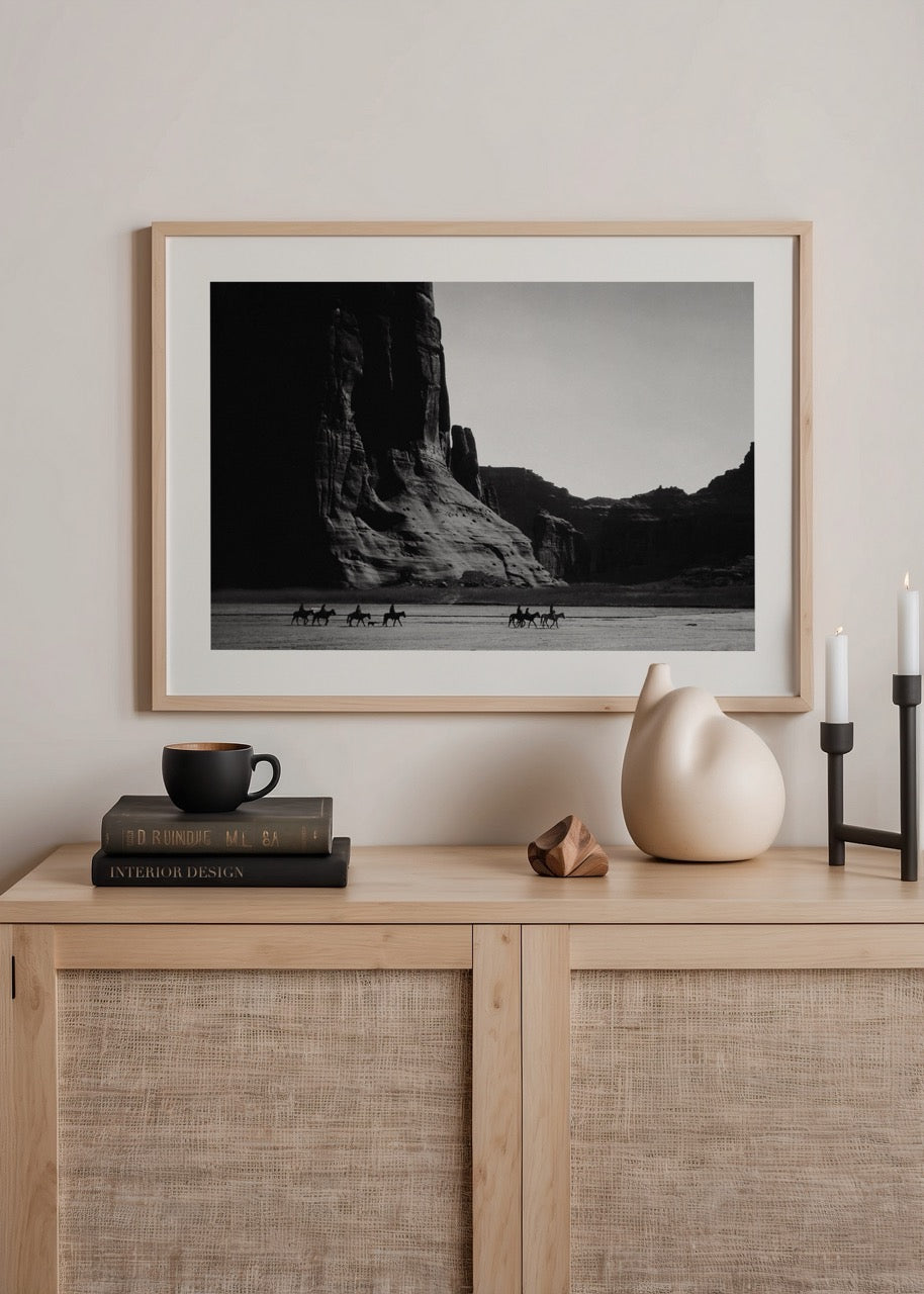 Çöl manzarasında ilerleyen atlı figürlerin yer aldığı siyah beyaz fotoğraf