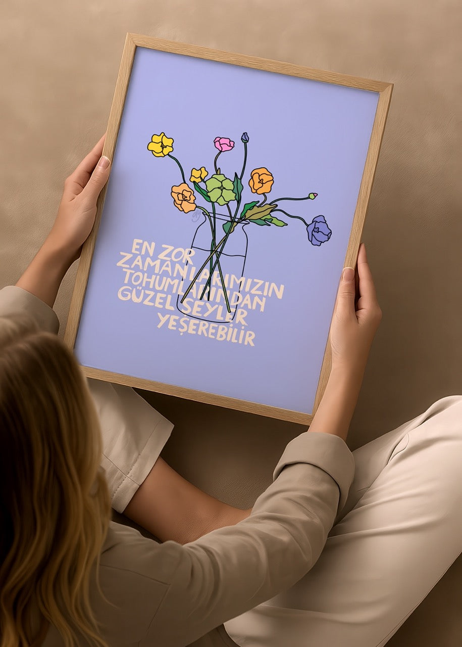 duygulariyerim’in “En Zor Zamanlarımızın Tohumlarından Güzel Şeyler Yeşerebilir” posteri – mavi fonda renkli çiçekler ve umut dolu bir mesaj
