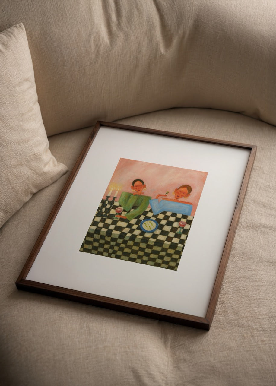 Nida Büyük imzalı Girls Night posteri, dama desenli masa ve mum ışığıyla iki kadının dostluk dolu akşamını anlatan modern sanat baskısı.