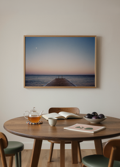 Gün batımında denize uzanan ahşap iskele, pastel gökyüzü ve ufukta görünen ayı betimleyen minimalist deniz fotoğrafı.