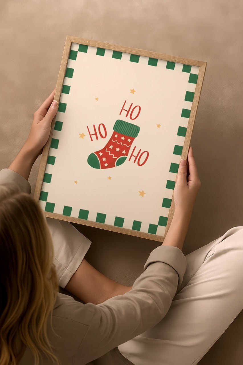 Nergis Sabancı imzalı HO HO HO Christmas Stocking posteri, kırmızı Noel çorabı ve yeşil kare çerçeveli yılbaşı temalı illüstrasyon baskısı.