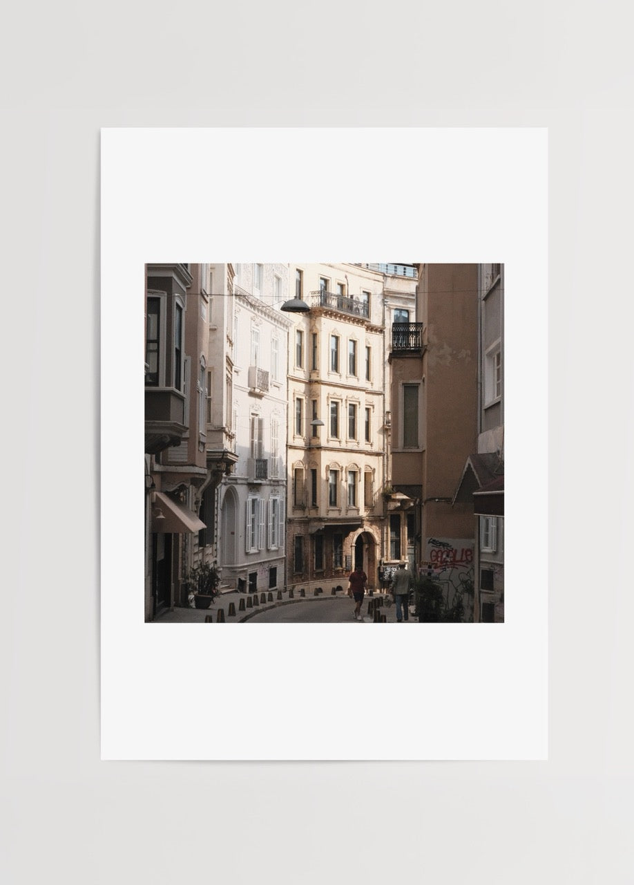 Merve Kurt İstanbul sokak fotoğrafı, sıcak gün ışığıyla tarihi binaları gösteren şehir posteri.