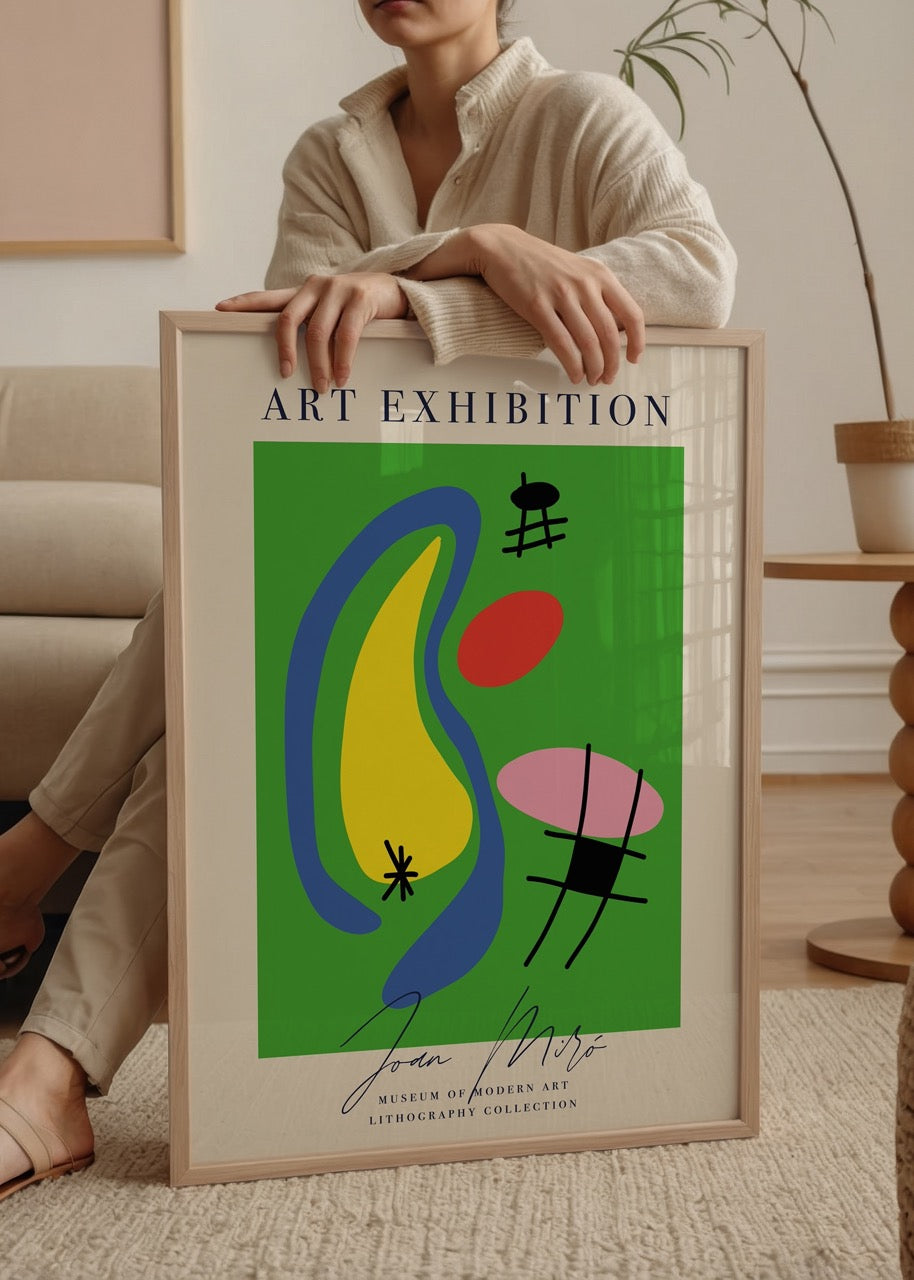 Yeşil zemin üzerinde sarı, mavi, kırmızı ve pembe şekillerin yer aldığı, Joan Miró imzalı modern litografi poster.