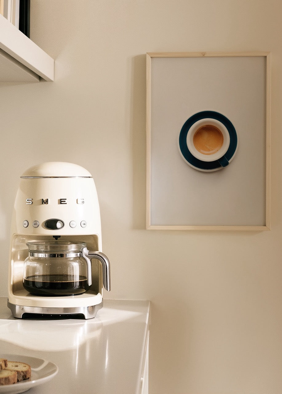 Beyaz zemin üzerinde lacivert fincanda sade bir espresso içeren minimalist kahve posteri