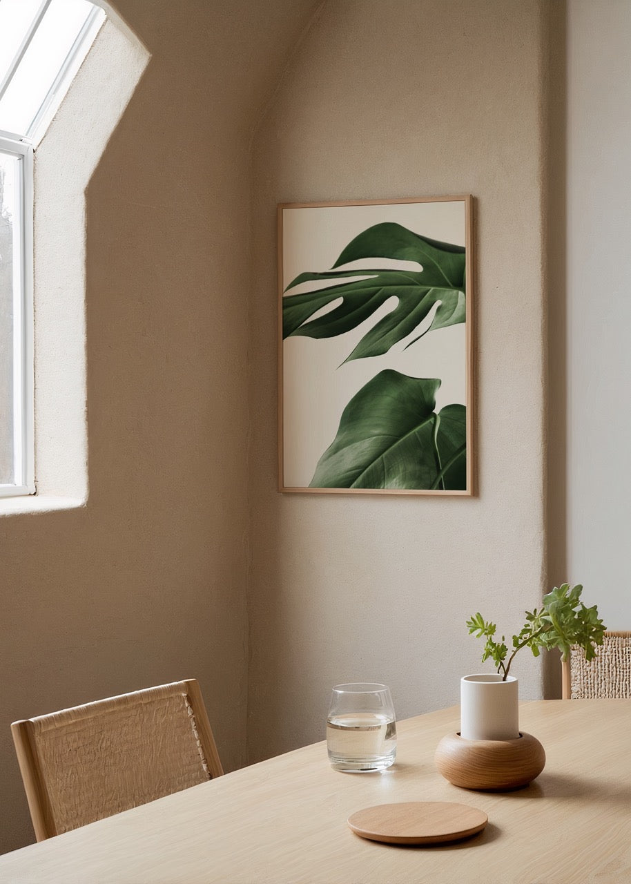 Beyaz arka plan üzerinde iki adet tropikal monstera yaprağını gösteren minimal botanik poster.