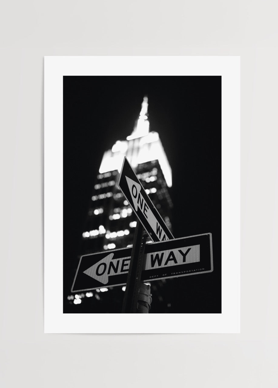 New York sokaklarında One Way tabelaları ve ışıklı gökdelen siyah beyaz fotoğraf