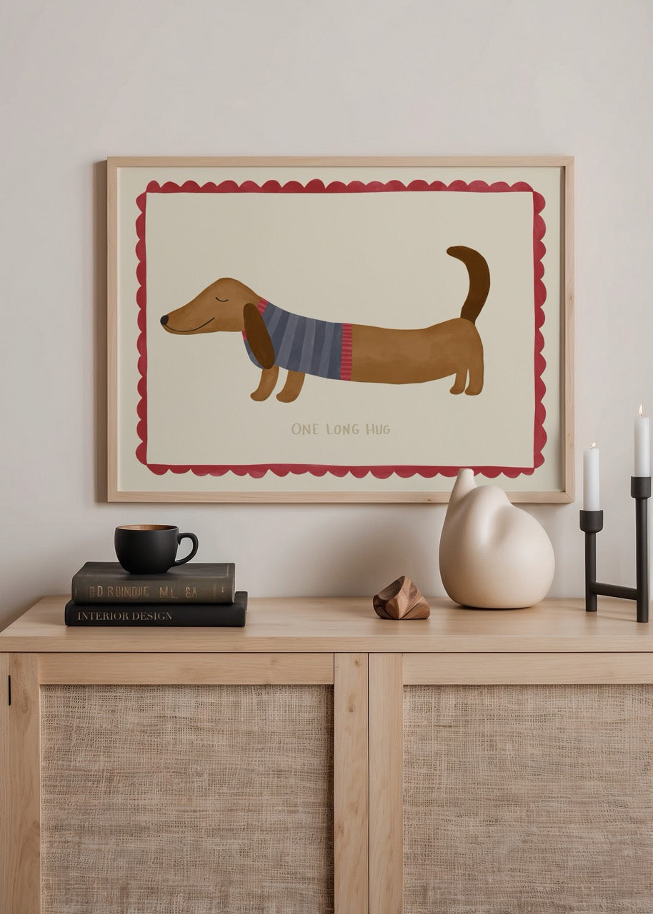 Krem zemin üzerinde, uzun gövdeli bir köpeğin yatay kompozisyonda betimlendiği, etrafı kırmızı çerçeveyle çevrili sıcak ve sevecen illüstrasyon.