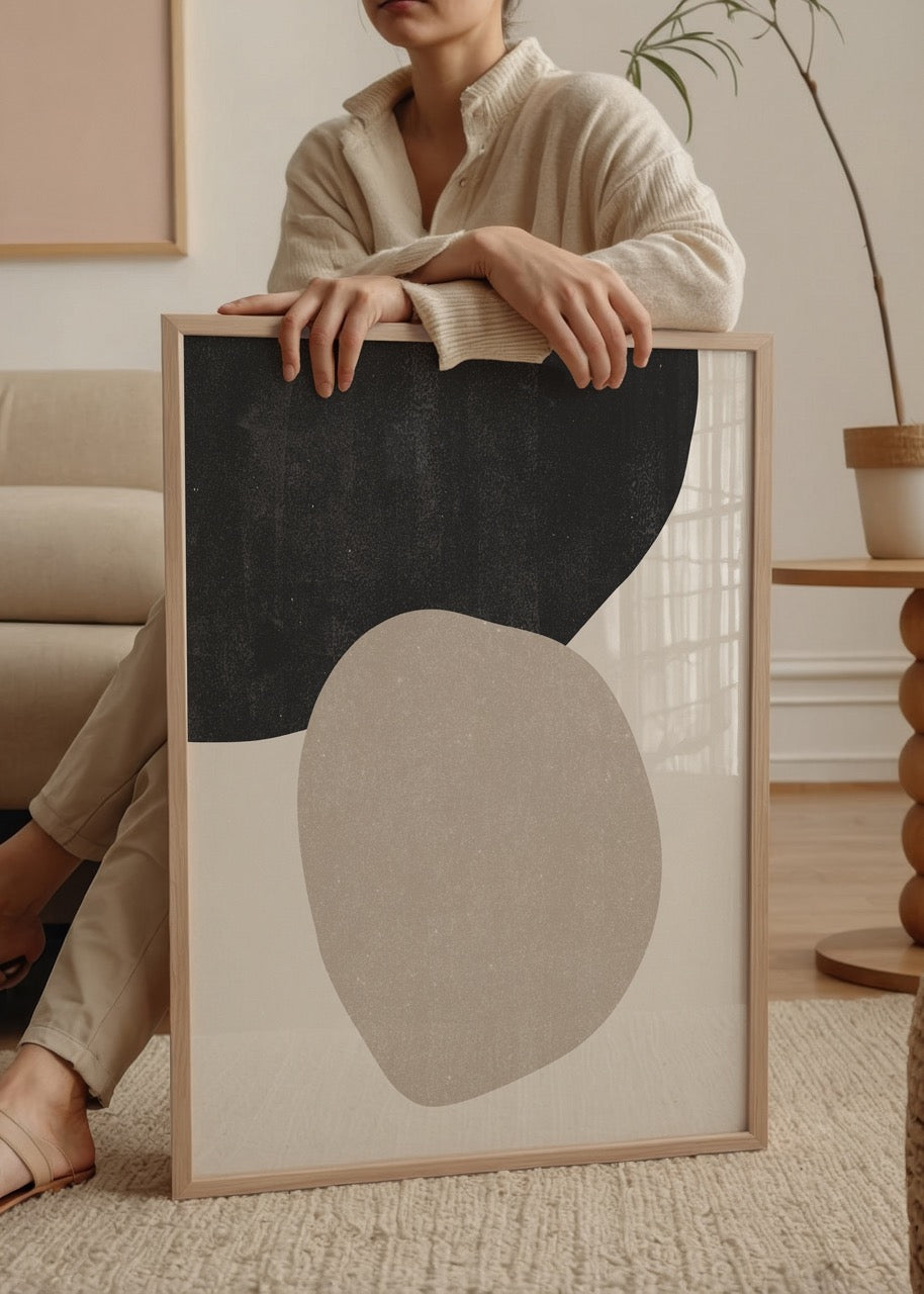 Soyut iki taş formunu andıran siyah ve bej renkli organik şekillerden oluşan minimalist sanat posteri.