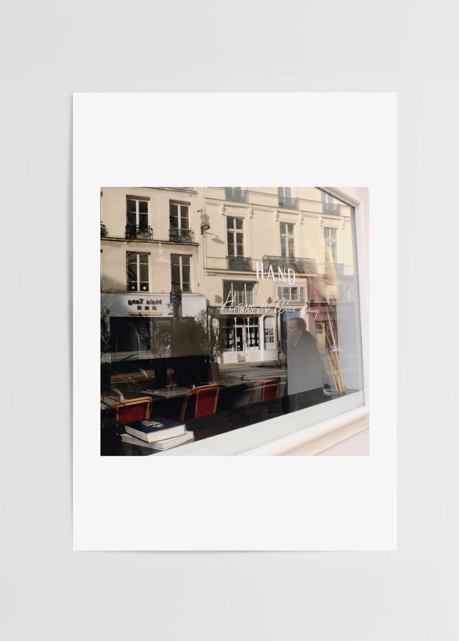 Merve Kurt’un Paris’te çektiği yansıma fotoğrafı, kafe camından şehir manzarasını gösteren dekoratif poster baskı.
