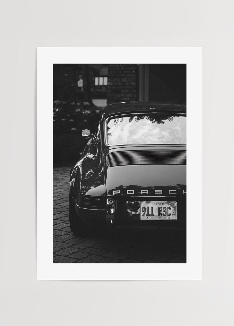 Porsche 911 modelinin arka görünümünü gösteren vintage siyah beyaz otomobil fotoğrafı