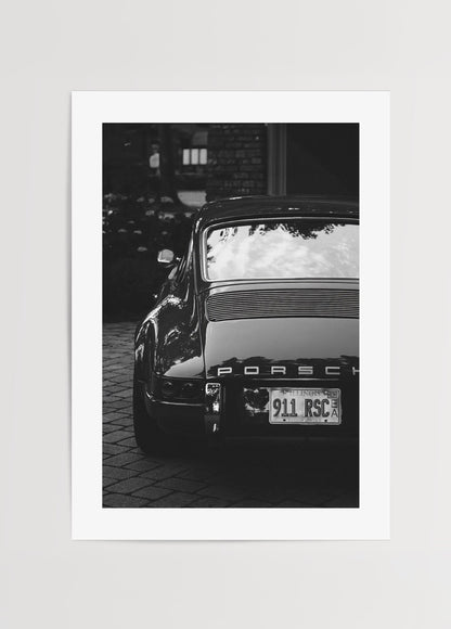 Porsche 911 modelinin arka görünümünü gösteren vintage siyah beyaz otomobil fotoğrafı