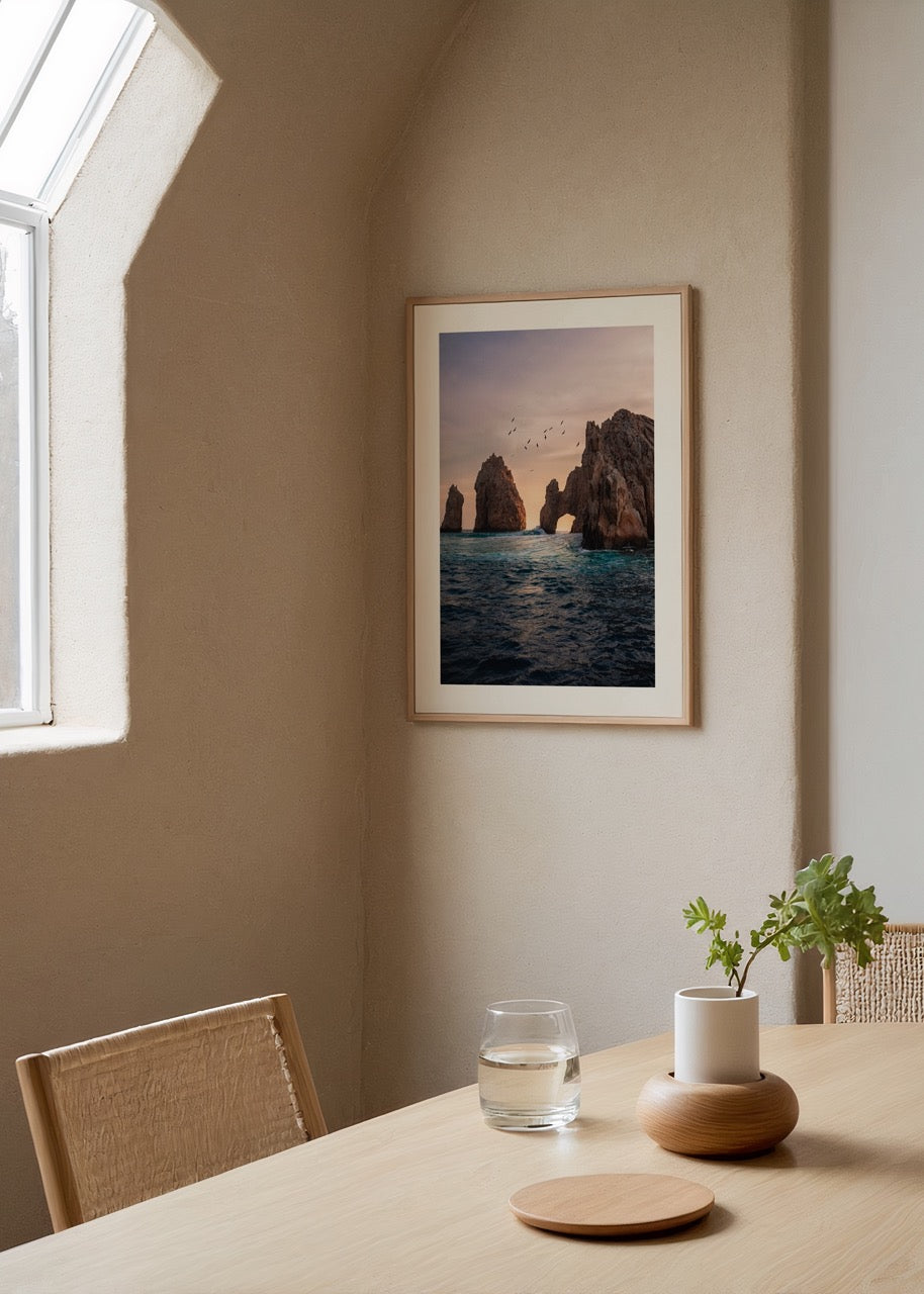 Gün batımında deniz üzerinde kaya kemerleri ve uçan kuşlar, doğa ve seyahat temalı poster.